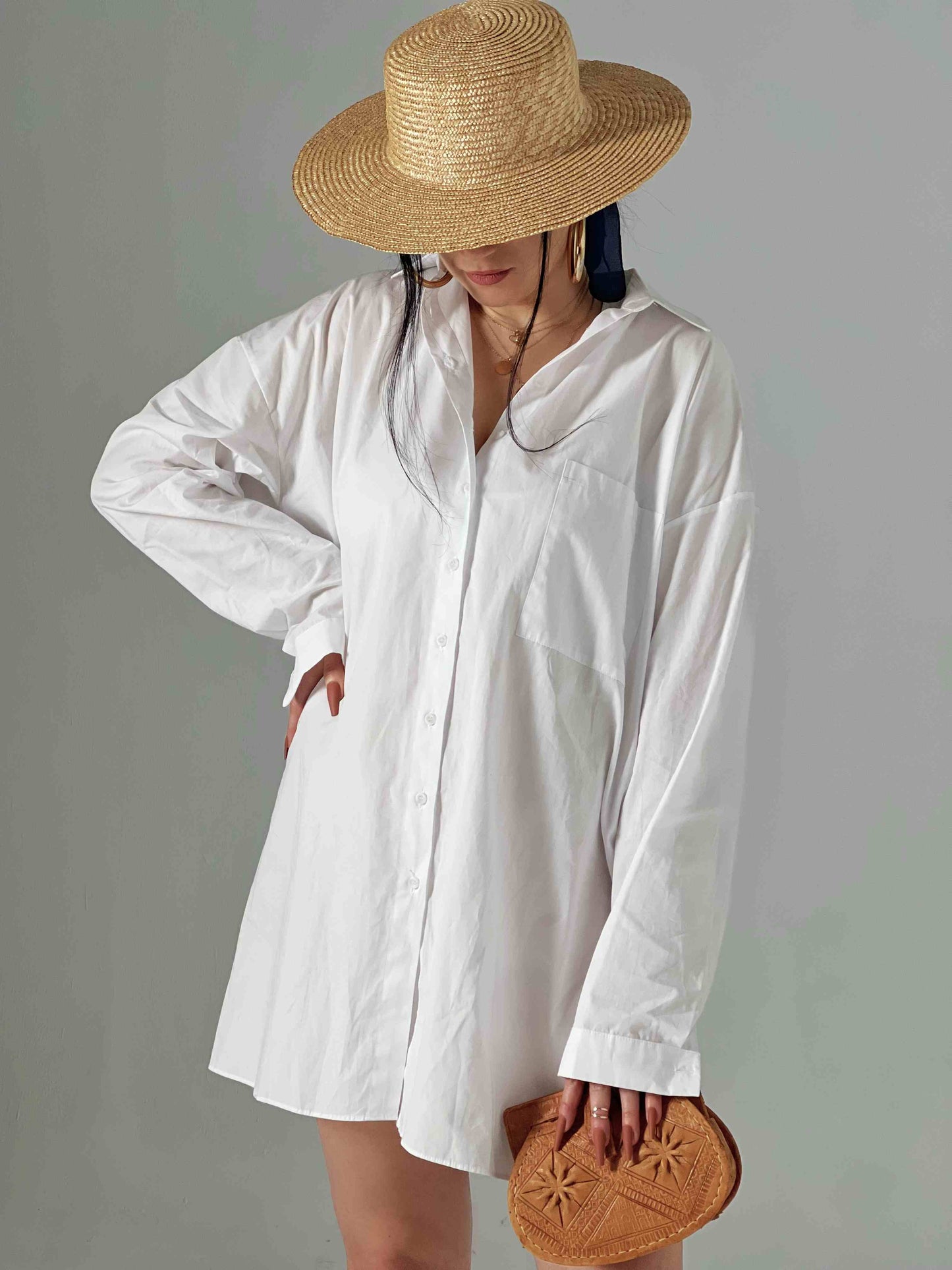 femme avec chapeau de paille portant juste une chemise blanche oversize